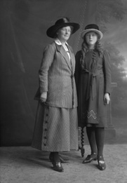 Young girl standing with mother.#   