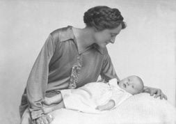 Mother with braids in hair looking over new baby.#