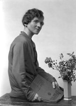Female portrait. As a prop she is holding 'Photographs of the Year 1925,' the annual review for 1926 of the world's pictorial photographic work. #