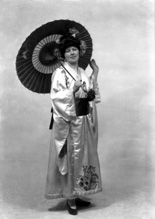 Carrie M. Cruickshank as Mimosa in the November 1927 production of 'The Geisha,' the story of a Japanese tea-house performed by the Northern Amateur Operatic Society. In the advert it was noted that prices would be increased for this attraction due to the lavish expense of the production (over ?200), in aid of the Queen Victoria Jubilee Institute for Nurses. A review noted that 'Miss Cruickshank has a beautiful voice, and went through the delicate Mimosa's ordeals of being sold and of selling with a sure finish.' #