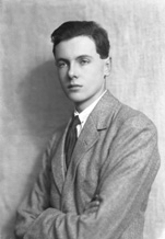 Young suited man with arms folded.#