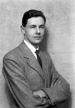 Young suited man with arms folded.#
