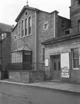 Bank Street, Inverness. The central building was used as the headquarters of Inverness District Scouts from 1931 to 1935, being then known as the Maud Lawson Hall, after Lady Maud Lawson of Dochfour, who had been a keen supporter of Scouting. The building was opened on 23rd June 1931 by the Prince of Wales, but was sold due to structural problems only four year later. Before 1931 the building was known as the Royal Halls. The Theatre Royal, on the far right,  burned down in 1934, causing a stir in Inverness at the time as people thought it had been predicted by the Brahan Seer who said that when a theatre in Inverness was built between two churches, it would be destroyed by fire. The theatre was situated on the riverside between the Free North Church and the St Columba Church. The building on the far left now houses the Riverside Gallery, and the central building is where CYC is located. Moray House now occupies the site where the Theatre Royal stood.*