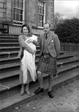Parents on steps, at time of baby christening.#