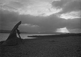 Landscape study of Beauly Firth from Kessock Ferry, with wrecked boat's bow on beach and sunlight shining through clouds.* 