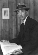 Man wearing hat reading a book.#
