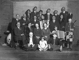 Group of people including musicians and clowns. #