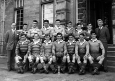 Rugby 1st XV 1956-1957. Rear: Mr Murray, David Richards, Peter Willis, Kenneth Gardener, Gerald Taylor, Ian Fraser, David Philip, Donald Campbell, Mr Buchanan. Front: Alastair Yeudall, Ian Robin, Robert Ewen, Roderick MacKenzie (C), Ewan Lawson, David   Moffat, James Wylie. (Courtesy Inverness Royal Academy Archive IRAA_004).