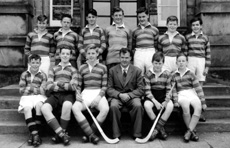 Shinty 1955-1956. Rear: Malcolm MacColl, Alan Stoddart, Hugh Boa, Ian Fraser, John Michael, Thomas MacLennan, David MacLean. Front: John Bolton, Colin MacLennan, Roderick MacIntosh, Mr Stewart, Ronald MacLean, James George. (Courtesy Inverness Royal Academy Archive IRAA_103).