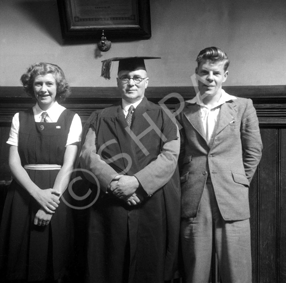 Inverness Royal Academy Dux 1948-1949. Rector MacDonald with James Mackenzie and Aileen Barr. The document hanging on the wall is a framed copy of an extract from Capt. William Mackintosh's will, which provided funding for children of the name of Mackintosh to receive free education, mainly at the Academy. 