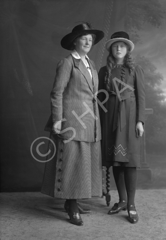 Young girl standing with mother.#   