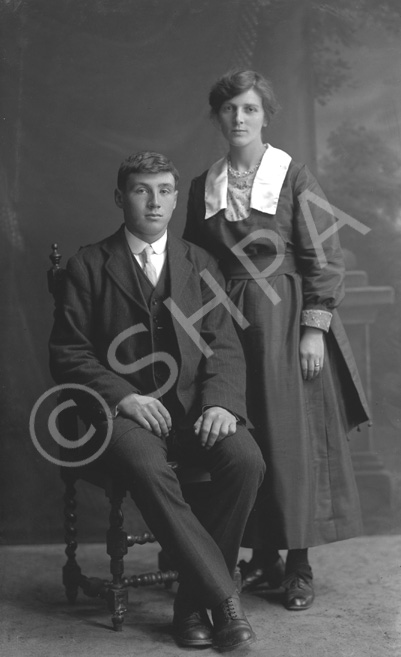 Young couple, man seated.# 