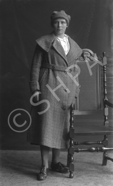 Young woman standing in overcoat. Slightly blurred image.#    