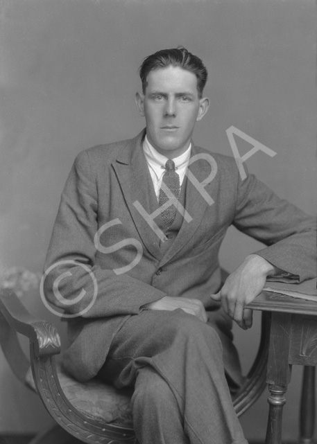 W. MacLean, seated with legs crossed......