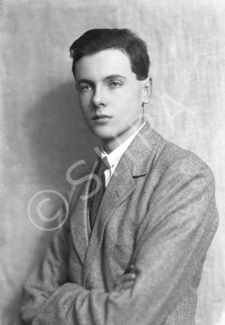 Young suited man with arms folded.#