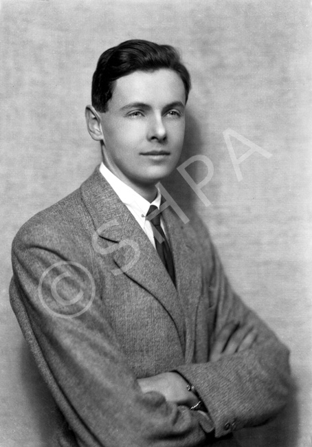 Young suited man with arms folded.#