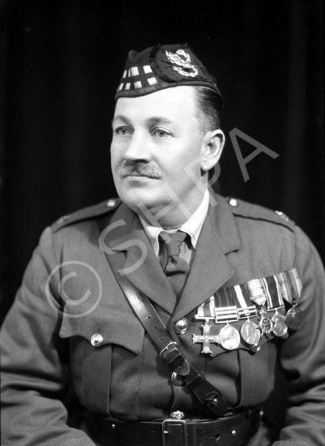 Major Donald Munro MC (1880-1932). He had been stationed at Fort George from 1921 until his death of pneumonia on 8 December 1932. His medals are the Military Cross (1915), Queen's South Africa Medal (1900), King's South Africa Medal (1902), the 1914 Star, British War Medal and Allied Victory Medal. 

A native of the Ardross district, the deceased came to Dingwall early in his youth and for a time served on the clerical staff of the late Mr William Paterson, corn and coal merchant, Dingwall. From there, he enlisted in The Seaforth Highlanders at Fort George on 8 February 1898 and he served with his regiment for exactly one month short of 34 years.

Major Munro had a very distinguished military career, starting as private, rising through all the grades, was commissioned on the field of war and in December 1929, he received his majority.

Enlisting at Fort George on 8 February 1898, he was posted to and joined the 2nd Battalion at Dover two days later. He served with the 2nd Battalion through the South African War, being present at the action at Whittebergen. He also took part in the guerrilla warfare towards the close of hostilities in the Transvaal and Cape Colony. He received the Queen's Medal with three clasps and the King's Medal, with two clasps. From South Africa he went to Ireland.

Appointed Lance Corporal in 1899, he was promoted Corporal in August 1903 and Sergeant in 1907. Whilst serving with the 2nd Battalion he was promoted Regimental Quartermaster Sergeant just prior to the outbreak of the Great War in 1914. He proceeded with the 2nd Battalion to France in 1914 and obtained a regular commission as Lieutenant on 1 October1915. He was appointed Lieutenant and Quartermaster and was promoted to Captain and Quartermaster on 1 October 1917, receiving his majority on 1 October 1929. For his services in the War, he received the Military Cross, as well as the 1914 Star, the British War Medal and the Victory Medal. He came home from France in February 1919 and in November of that year he was in India with the battalion. In December 1921, he was posted from the 2nd Battalion at Meerut, India, to the Depot, Fort George.

As private, NCO, and officer, Major Munro was ever popular in his regiment, his chubby, round, smiling face being a source of happiness to his companions, to the men under him and to his fellow officers. He was recognised for his ability as a statistician, his integrity and perfect fairness, his courtesy and willingness to serve others, and above all his love of his regiment, the history and traditions of which he knew, chapter and verse.

His funeral took place from Fort George to Ardersier Cemetery with Military and Masonic honours. The gathering of mourners was large and was representative of the military life of the Highlands. The numerous, beautiful wreaths bore ample testimony to the respect and popularity in which the late officer was held. A short service at the house was followed by an impressive service in the Garrison Church, conducted by the Rev. William Graham, Ardersier, who also officiated at the service at the graveside.

 Taken from his Obituary in The Ross-shire Journal