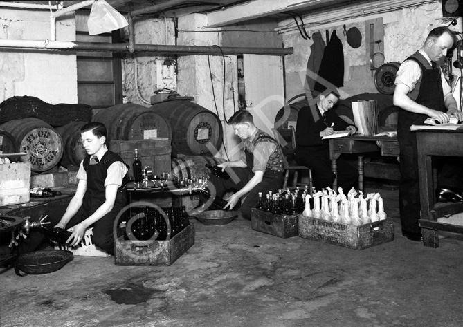 Messrs Alexander MacDonald & Co, Wine Merchants, 49-53 Church Street, Inverness (established 1837). Cellar workers bottling.*  