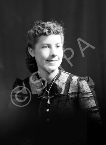 Miss Proudfoot, Highland News office, wearing aeroplane-shaped necklace. 