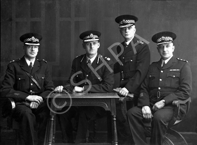 Mrs Johnston, Bridge Street, Inverness. Identification information kindly provided by Dave Conner and Duncan Chisholm.  Officer on the left is Acting Chief Constable Andrew Meldrum, appointed on 7th August 1944 when Chief Constable Stewart was summoned to the fledgling Control Commission for Germany.  Second left is Chief James Douglas Stewart, a Canadian from Winnipeg, who was appointed Chief Constable of Inverness Burgh on 11th January 1943 after previous service in the City of Dundee Police. Stewart was later seconded to the Control Commission for Germany from 1944 until August 1946 as the Deputy Inspector General of the Special Police Corps for Germany, with the rank of Colonel.  The other two officers on the right are Burgh Special Constables with Inspector rank. The officer on the far right is Hugh W Johnstone of 17 Bridge Street, Inverness. He lived at Culduthel Gardens. One of his brothers owned a shoe shop on Grant Street and the other, Daniel, lived next to Chief Constable Paterson at the corner of Ballifeary Road and Glenurquhart Road.