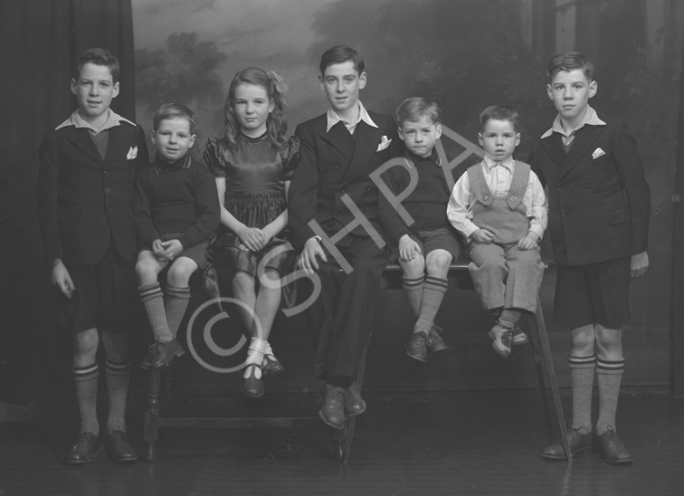 Stewart, Kessock Avenue, Inverness. Jimmy (far left) was twin brother to Sandy (far right). Willy (second left) was twin brother to Robert (third right). Mary and John. John was born a twin to Peter who died at 3 months. George Stewart (second right) is the only surviving sibling (2012). Unsure why the negative envelope has the address as Kessock Avenue. The Stewart family lived in Maclennan Crescent, Inverness.
