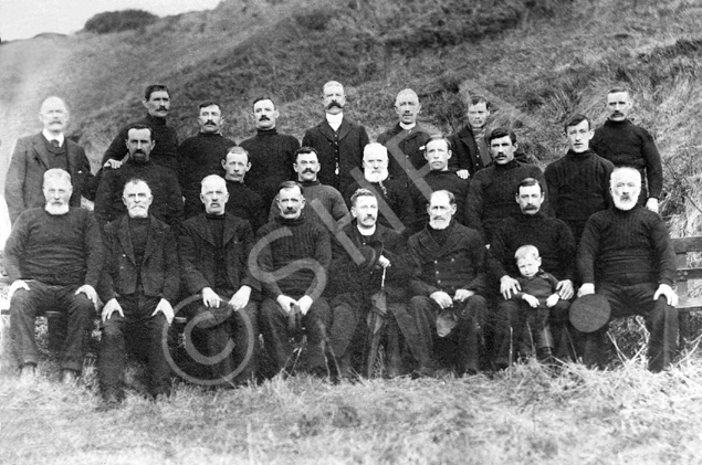 Copy of Ardersier fishermen and a minister c1900 for Mr Johnstone, Australia. Seated left to right: 'Pettachan' Johnstone, Alexander 'Sandy' Cameron, John Johnstone ('Jocky Petty'), Davy Johnstone, Reverend Paton or D. McLeod (?), 'Paddy', Sonny (or Sammy) Davidson and son 'Bumber', and Donald 'Dole' Johnstone. Middle row left to right: Dave Cameron, William Bow (?), Alex 'Moses' Johnstone, Donald Cameron, Aly MacDonald, Dunk Johnstone, Nicky Davidson, and Jim Johnstone. Back row left to right: Alex 'Oak' Davidson, John Cameron, James Main, 'Secky' (?) Campbell, James Forsythe ('Jimmak the Mason'), Jamie Paddy, and Davie 'Honeyman' Main.