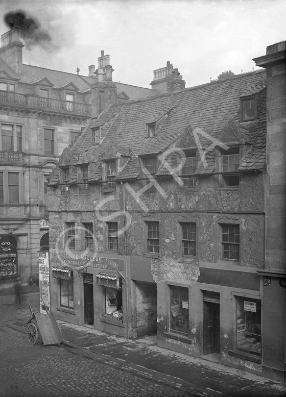 Church Street Inverness, showing fishmongers and old roofing, building built in 1700 for James Dunbar of Dalcross. By mid-19th century it was occupied by tradespeople, and was demolished in 1900. The site later housed the Clydesdale Bank and the four triangular pediments were preserved inside the building. They have not been seen however, since the bank moved premises in the 1980s. The corner building is now a bar called The Room.*