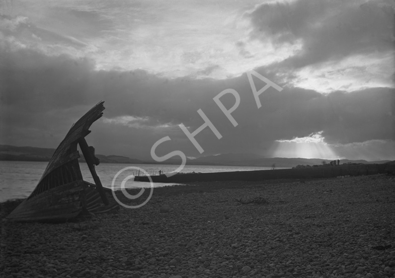 Landscape study of Beauly Firth from Kessock Ferry, with wrecked boat's bow on beach and sunlight sh.....