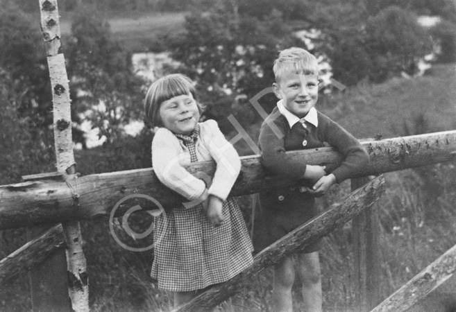 Mrs Seex, two children on a wooden gate. 