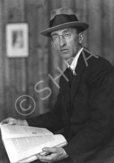 Man wearing hat reading a book.#