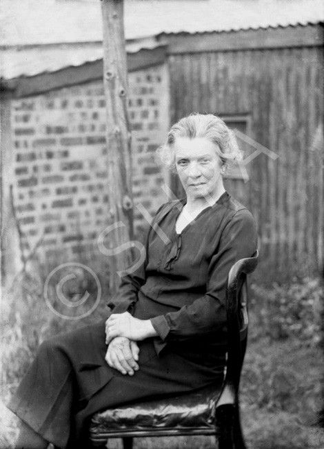 Older woman portrait, seated outdoors.# 