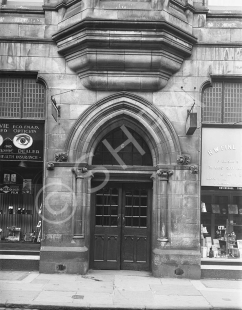 Street level facade of the Inverness Town House in Castle Street, built between 1878-1882. To the left of door no.6 was an opticians, who also dealt with health insurance, cameras and film. To the right was W.H. Finlay & Co, Publishers & Stationers - 'Official Printers to Inverness' with an office in London. *