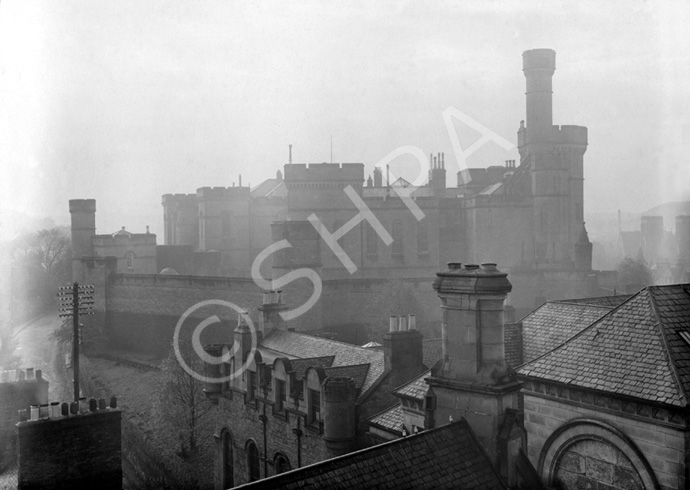 Mist over Inverness Castle with its old high outer walls, from across the rooftops of the now long gone buildings that once occupied the site of the present Tourist Bureau and Museum. Taken from the roof of the town house. Compare with image: H-0255. Courtesy John and Aithne Barron. * 