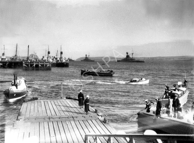 People at Invergordon queuing to take a trip by speedboat to the wreck of the HMS Natal c1932-1938. Two 'R' (Royal Sovereign and/or Revenge Class Battleships in the firth with two Birchol Class Fleet Oilers of the RFA lying alongside the pier.*