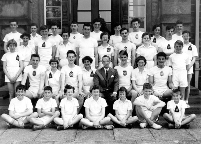 Inverness Royal Academy Athletics 1956-1957. Rear: Ronald Smith, Doreen Hamilton, Roderick MacFarquhar, William Paterson, Roderick MacKenzie, David Philip, Kenneth MacLennan, Winnona Duncan, George Ross. 2nd row: Marion Renfrew, Ian Fraser, Helen Simpson, Peter Willis, Winnifred Elliot, Donald Campbell, Robin MacDonald, Peter Strachan, Hazel MacPherson. 3rd row: Anne Dunn, Gerald Taylor, Janet Campbell, Ian Nicol, Maureen Bruce, Mr Murray, James Wylie, Kathleen Russell, Kenneth Gardener, Kenneth MacKenzie. Front: James Grant, Ronald Morrison, Shelagh Hamilton, Hillary Best, Fiona MacPherson, Alan Cunningham, Norman Thompson. (Courtesy Inverness Royal Academy Archive IRAA_005).