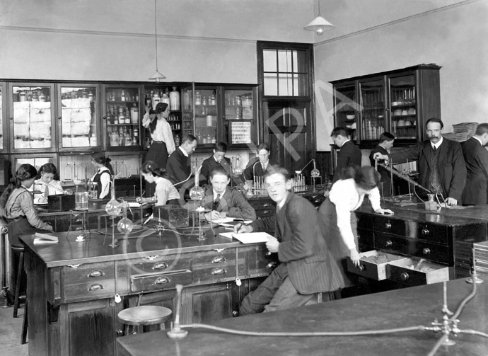 Inverness Royal Academy Science Laboratory, Academy, 1912. Between 1895-1980 the IRA was located in the Midmills building, currently the UHI-Inverness College (2013). The classroom scene was photographed at the time of the completion of the first extension to the Academy, running along Midmills Road opposite the side entrance to the Crown Church. The accommodation was shared in the early years with Inverness High School, when that school occupied the building which now houses the Crown School, only a short distance away. Accommodation included rooms for science and art, with a gymnasium and these are 'posed' publicity shots. This image was captioned Science Lab of Mr J.M. Lowson, MA BSc, Science Master, in the Highland Times, 2nd July 1914. (Courtesy Inverness Royal Academy Archive IRAA_053).