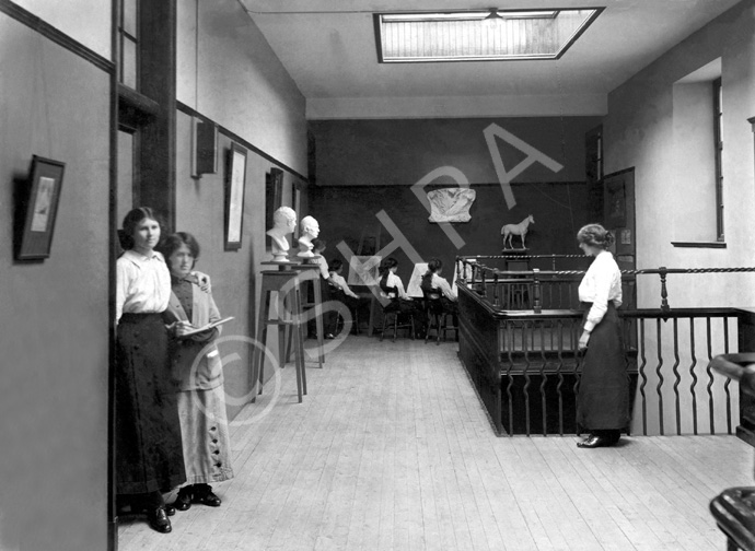 Inverness Royal Academy Corridor, Art Department, 1912. Between 1895-1980 the IRA was located in the Midmills building, currently the UHI-Inverness College (2013). The classroom scene was photographed at the time of the completion of the first extension to the Academy, running along Midmills Road opposite the side entrance to the Crown Church. The accommodation was shared in the early years with Inverness High School, when that school occupied the building which now houses the Crown School, only a short distance away. Accommodation included rooms for science and art, with a gymnasium and these are 'posed' publicity shots. (Courtesy Inverness Royal Academy Archive IRAA_054).