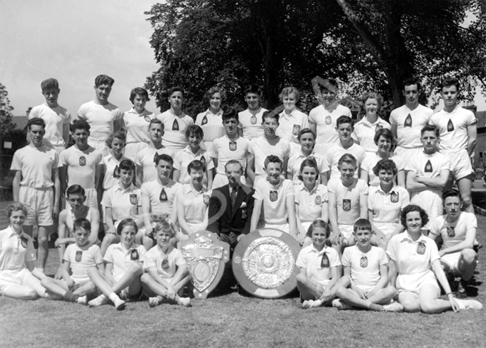 Inverness Royal Academy Athletic team 1954-1955. Rear: Alasdair Finlayson, Ian Philip, Carol Robertson, Alec Paterson, Ishbel Cameron, Kenneth Gardener, Joan Marshall, Roderick MacKenzie, Winnifred Elliot, William Stoddart, Donald Campbell. 2nd row: John Urquhart, James Pennan, Marion Renfrew, Ian Robin, Maureen Bruce, James Wylie, Seumas MacInnes, Helen Simpson, Ian Nicol, Catherine MacInnes. 3rd row: Peter English, Margaret Sinclair, John MacLellan, Dorothy Lamont, Mr Murray, Alastair MacLeod, Sheena Campbell, John Robertson, Isla Rose, William McGuire. Front: Margaret Campbell, Ross Henderson, Winona Duncan, Douglas Thomson, Shona Robertson. (Courtesy Inverness Royal Academy Archive IRAA_091).