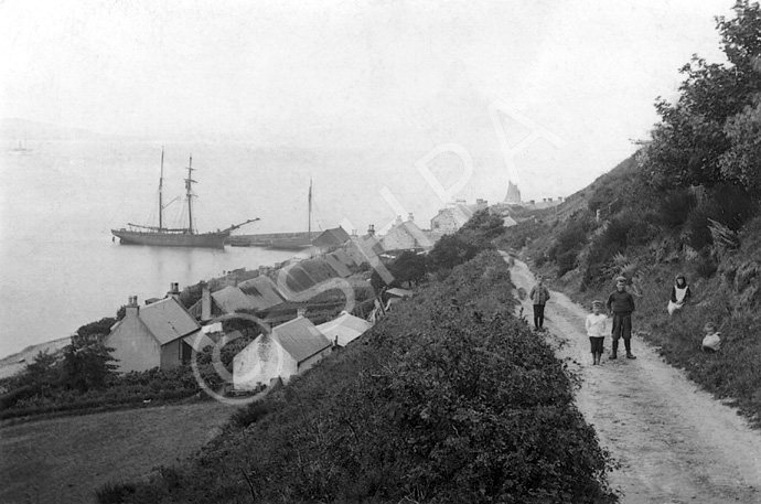 Grain ship making a delivery at North Kessock, on the Black Isle. The grain was stored opposite the East Pier. The dirt track the children are on is the Old Craigton Road. Submitted by Margaret Paterson. (AP/H-0266) *