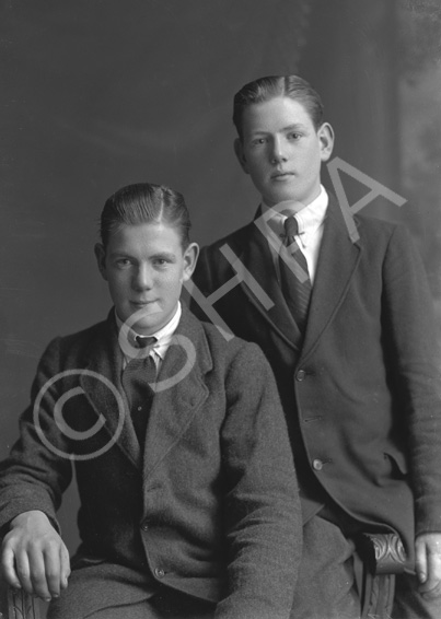 Two young men, one seated, possibly brothers.#    .....