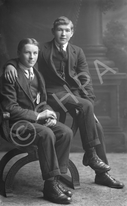 Two young men, both seated, possibly brothers.#    .....